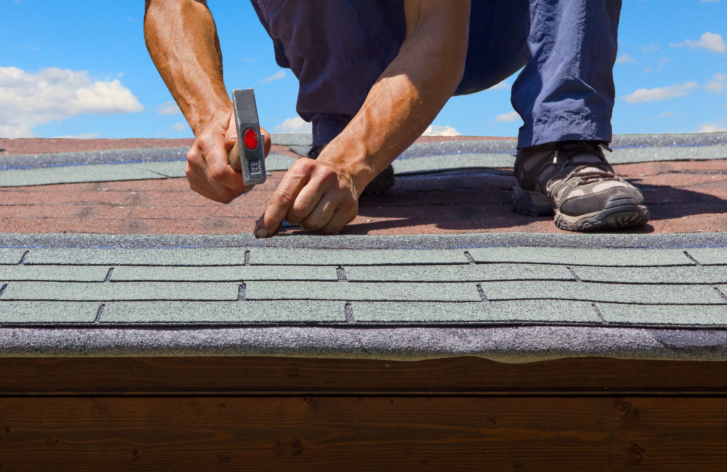 Worker working on the roof shingles
